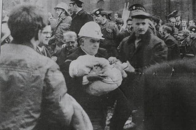 The body of Colin Nicholl, aged 17 months, is carried from the scene of the December 1971 Shankill Road bomb
