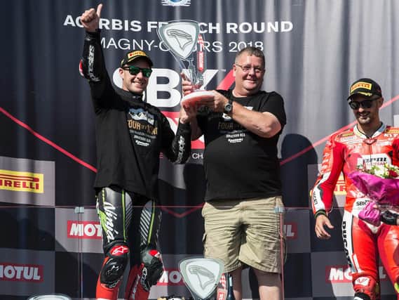 Jonathan Rea celebrates his record fourth World Superbike title on the podium with his father, Johnny, at Magny-Cours in France.