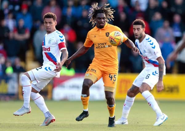 Livingston's Dolly Menga (centre) vies with Rangers' James Tavernier (left) and Connor Goldson