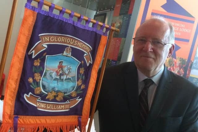 Provincial Grand Master, Steve Kingston, with a miniature Orange banner which is part of the exhibition at Liverpool Museum