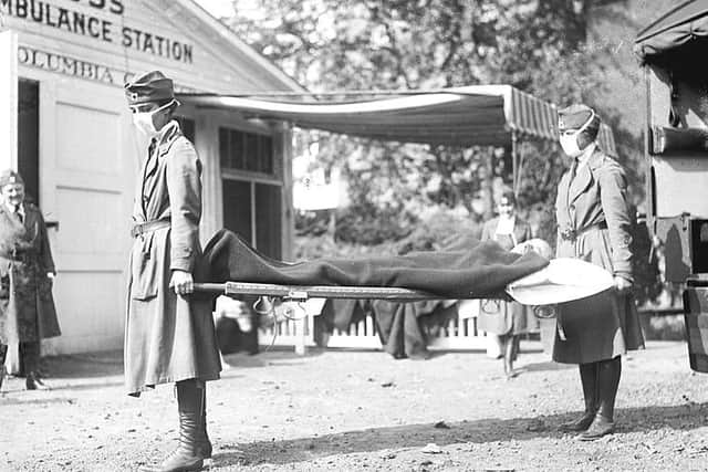 Masked Red Cross workers demonstrate emergency flu 'Ambulance' in Washington, 1918