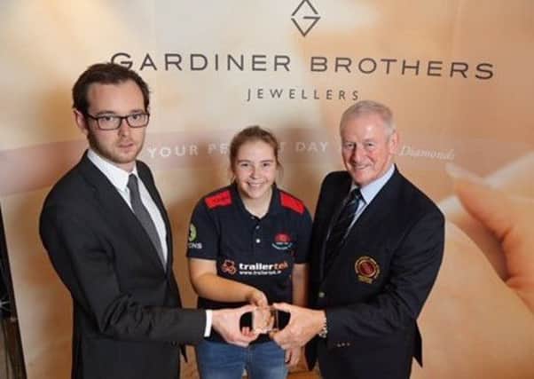 Cara Murray receives a prestigious Gardiner Brothers award from Michael Warke of Gardiner Brothers and Clarence Hiles, president of the Northern Cricket Union.