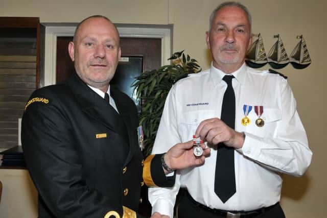 Kenny McDowell receives a long service medal from Peter Mizen, Head of HM Coastguard Coastal Operations, in recognition of his 40-plus years service with the Portmuck team. INLT 39-200-AM
