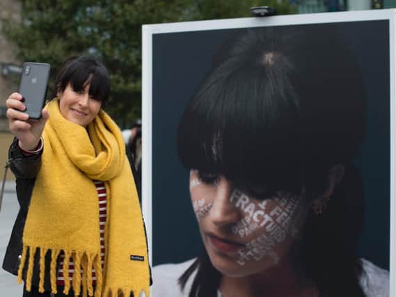 Anna Richardson takes a selfie by a portrait of herself at an outdoor exhibition in Regents Place in London, during the launch of the Lets Talk campaign, to encourage people to talk about mental health.