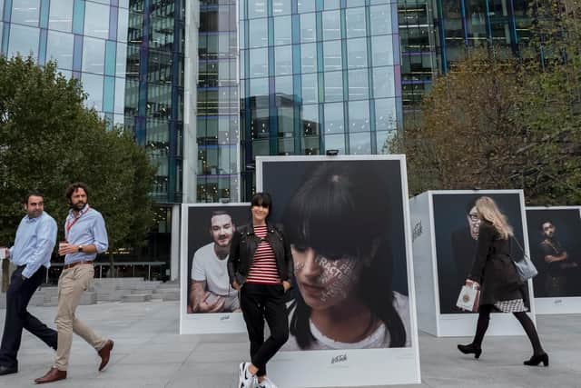 Anna Richardson stands against a portrait of herself at an outdoor exhibition in Regents Place in London, during the launch of the Lets Talk campaign, to encourage people to talk about mental health.