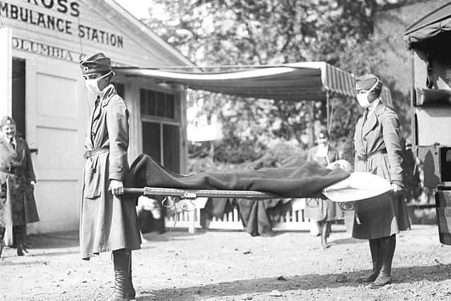 Masked Red Cross workers demonstrate emergency flu 'Ambulance' in Washington, 1918
