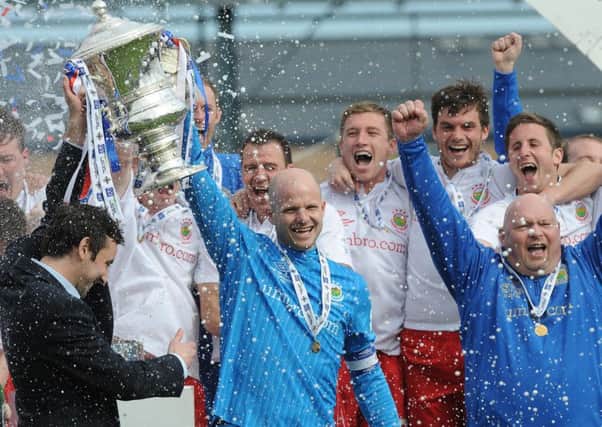 Linfield's Alan Blayney lifts the trophy following victory in the Irish Cup final over Crusaders in 2012.