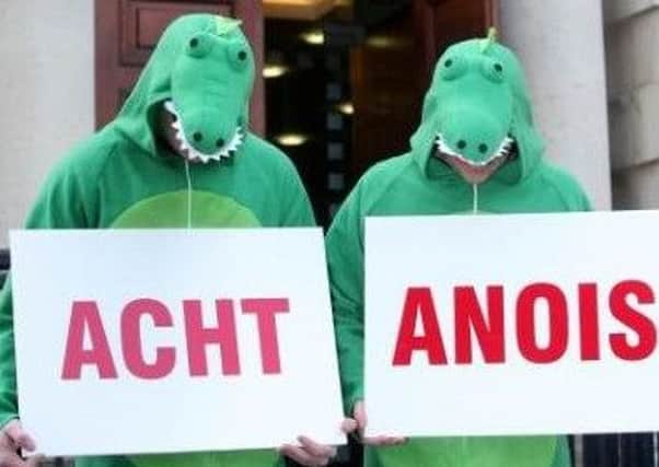 Campaigners dressed as crocodiles bearing signs demanding an Irish language act now