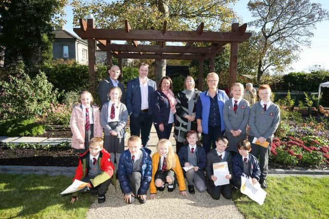 (back row l-r) Roy Beggs MLA; David Maxwell, BBC Radio Ulster Gardener's Corner presenter; Paula Bradley MLA; Geraldine Gilpin, chief executive, Abbeyfield & Wesley Housing Association; Barbara Kelso, garden designer with students from Carrick Model Primary School at the official opening of the new community garden.