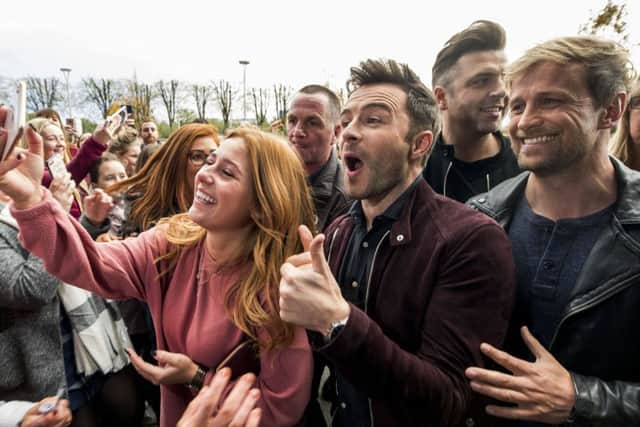 A fan takes a selfie with Westlife's Shane Filan and Kian Egan outside the Belfast SSE Arena, ahead of the press conference for tickets going on sale for their reunion tour. Pic by Liam McBurney/PA Wire