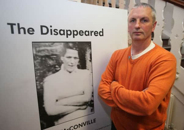 Michael McConville beside a picture of his mother Jean, who  was abducted and murdered by the IRA in 1972