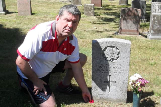 Iain Lendrum at the grave of Pte Robert Hall.