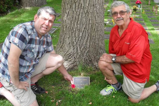 Iain Lendrum (left) and Bob Anderson lay a poppy at the tree planted in memory of WW2 veteran Cecil Anderson.