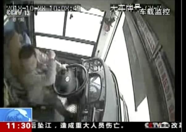 In this image taken from Sunday, Oct. 28, 2018 surveillance video footage run by China's CCTV via AP Video, a bus driver strikes a passenger moments before the bus plunged off a bridge into the Yangtze River in Wanzhou in southwestern China's Chongqing Municipality. Police say a brawl between a passenger and a bus driver was the cause of the bus plunging off a bridge and killing more than a dozen people in southwestern China on Sunday. (CCTV via AP Video)