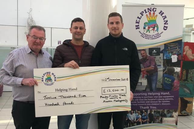 Adam and Greg present a cheque for Â£12,500 to Nigel Kearney (left) from the Helping Hand charity.