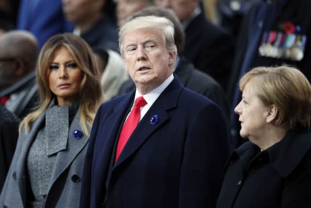 President Donald Trump, his wife Melania Trump, left, and German Chancellor Angela Merkel attend ceremonies at the Arc de Triomphe Sunday, Nov. 11, 2018 in Paris. . Over 60 heads of state and government were taking part in a solemn ceremony at the Tomb of the Unknown Soldier, the mute and powerful symbol of sacrifice to the millions who died from 1914-18.. (AP Photo/Francois Mori, Pool)