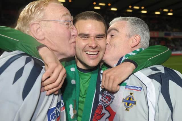 David Healy gets a kiss from Northern Ireland team attendants Terry Hayes and the late, Derek McKinley during a Euro 2008 qualifier against Denmark at Windsor Park in Belfast.