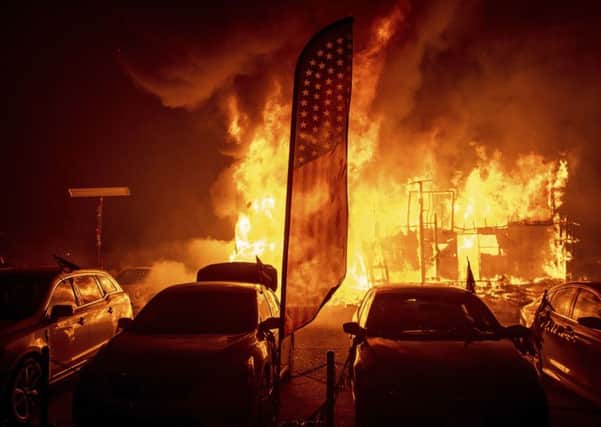 Flames consume a car dealership as the Camp Fire tears through Paradise, California, on Thursday, Nov 8, 2018.