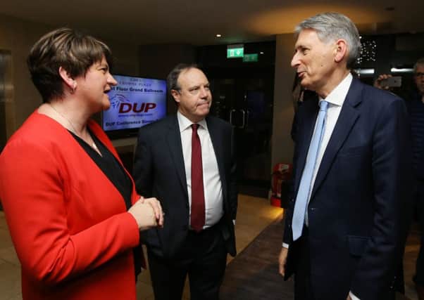 Chancellor of the Exchequer Philip Hammond (right) talks to   DUP leader Arlene Foster and deputy leader Nigel Dodds before addressing a party fund-raising dinner