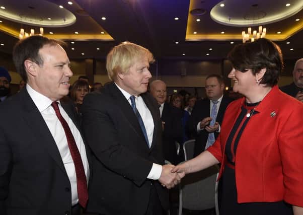 DUP deputy leader Nigel Dodds looks on as Boris Johnson MP shakes hands with DUP leader Arlene Foster during the DUP annual conference at the Crowne Plaza Hotel in Belfast on Saturday. Photo: Michael Cooper/PA Wire