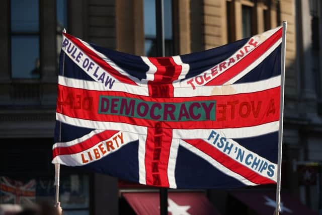 A protester holds a Union flag with slogans including "Democracy", "Rule of Law", "Liberty", "Tolerance" and "Fish 'n' Chips" during the People's Vote March for the Future in London, a march and rally in support of a second EU referendum: Saturday October 20, 2018