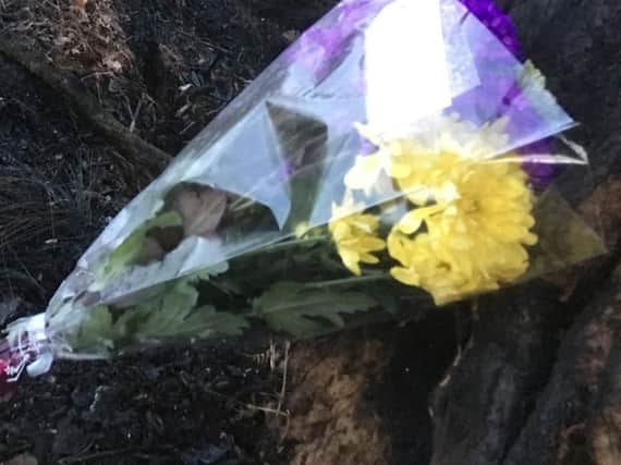 Flowers mark the scene of the crash