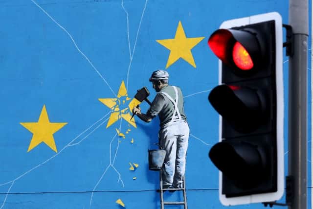 A view of a Banksy Brexit mural in Dover, Kent, of a man chipping away at the EU flag