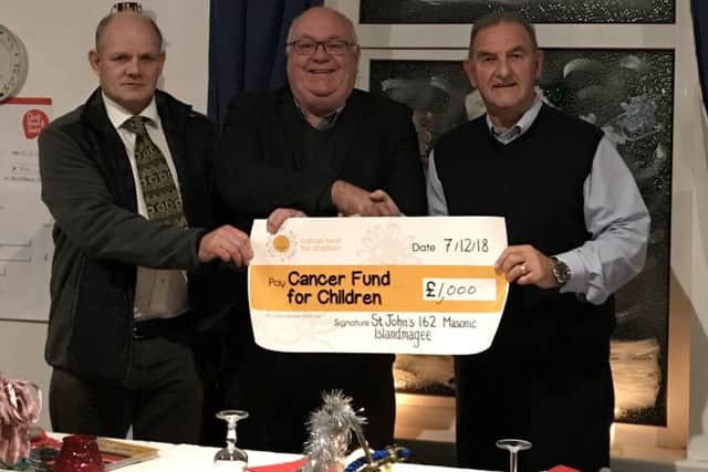 Ken Brundle (centre), NI Cancer Fund for Children, receiving a cheque from David Coburn and WM Jim McCord.