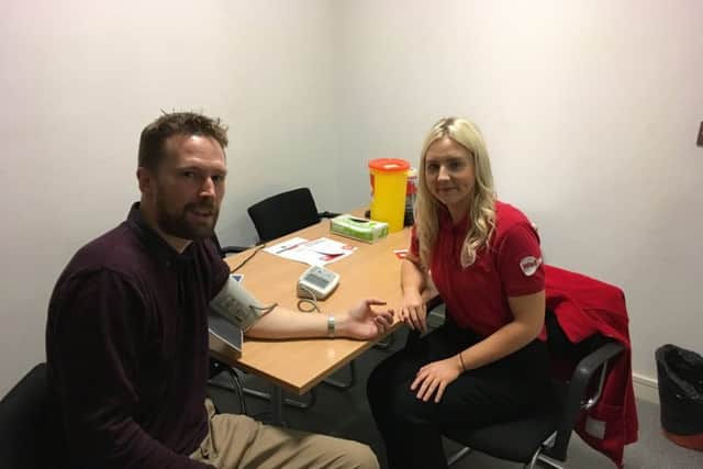 News Letter reporter Duncan Elder gets his blood pressure checked by Amy Coey, NICHS health promotion officer.