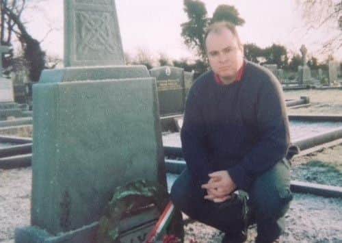 David Kelly pictured paying his respects at his father's grave.