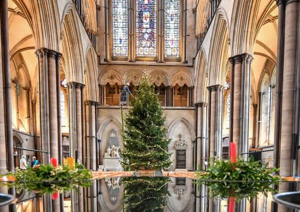 A joiner at Salisbury Cathedral decorates the 34ft Norway Spruce Christmas tree earlier this month.  Peter Lynas, writing about the festive season, says: "People sing carols, go along to school nativities and perhaps even go to church without believing in any of it" Photo: Ben Birchall/PA Wire