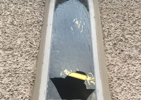 Image of window smashed with metal bar at Ballyclare Free Presbyterian Church
