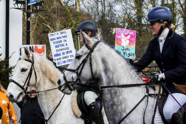 Riders pass anti-fox hunt protesters on Main Street Crawfordsburn during the North Down New Year Hunt in Crawfordsburn, Northern Ireland. Photo credit: Liam McBurney/PA Wire