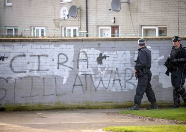 Police officers walk past Continuity IRA graffiti on a wall in the Lurgan area in 2009