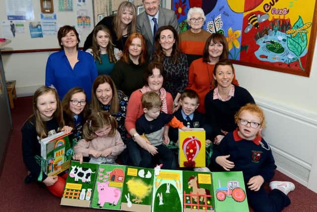 Members of Lurgan Deaf Club have created specially designed tactile books for local children who are visually impaired. Front row Blathnaid and Eibhleann Girvan, their mum Eleanor with Nessa. Ann Sterritt with her son Ben, Connal and Meadbh Bustard with Cara. Second row Alison Rooney Sensory Disability Team Manager, Adele Magill social worker, Jill McKeown Artist, Eilish Kilgallon Community Access Worker for Deaf people, Una McConville Social Worker, Back row Pat McAteer Specialist Services Manager, Southern Trust Beverley Lappin Social Worker, Kath Byrne Lurgan Deaf Club.