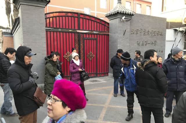 Anxious parents gather at an entrance gate to the Beijing No. 1 Affiliated Elementary School of Xuanwu Normal School after a male attacker injured 20 children. Pic by AP Photo/Ng Han Guan