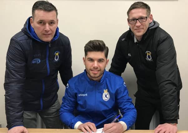 Evan Moran (centre) signs at Dungannon Swifts as club chairman Keith Boyd (left) and manager Kris Lindsay look on. Pic courtesy of Dungannon Swifts.