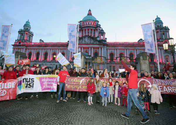 Protestors outside Belfast City Hall as it was lit up in red in support of the Irish language