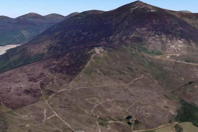 The large mountain to the right of the frame is Slieve Binnian (about 747m, or over 2,451ft). On the left of the image is Silent Valley reservoir. The smaller rise in the forground is Wee Binnian (about 460m or so, or 1,509ft).  Image from Google Maps.