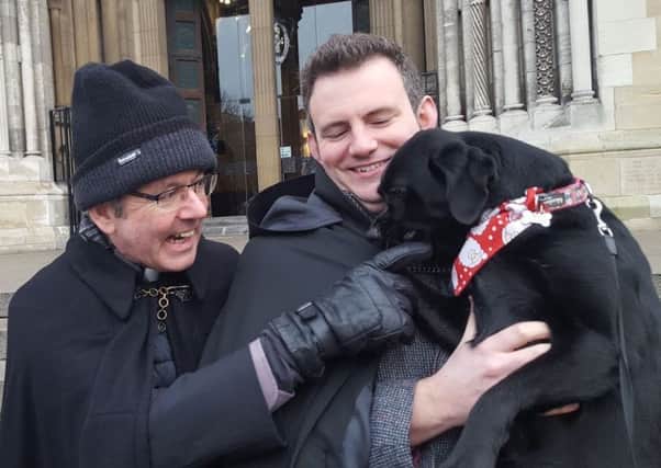 Rev Ian Mills and his dog Xena joined Dean Stephen Forde (left) on the steps of Belfast Cathedral for the Black Santa Sit-out in 2018