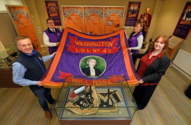 Outreach officer David Scott, curator Jonathan Mattison, and service officers Coleen Large and Helen Johnston with an unusual Orange banner from the United States