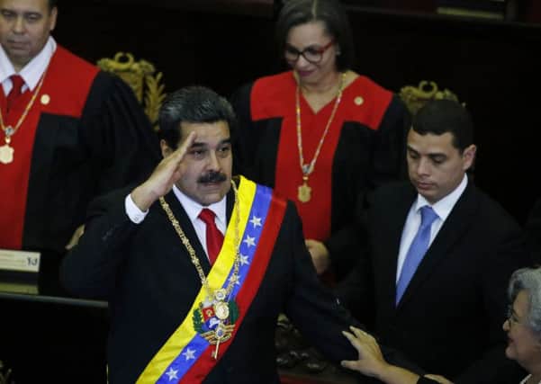 Venezuelan President Nicolas Maduro salutes as he arrives to the Supreme Court for an annual ceremony that marks the start of the judicial year in Caracas, Venezuela, Thursday, Jan. 24, 2019. Maduro was controversially inaugurated earlier in the month, with the opposition claiming to have won the presidential election (AP Photo/Ariana Cubillos)
