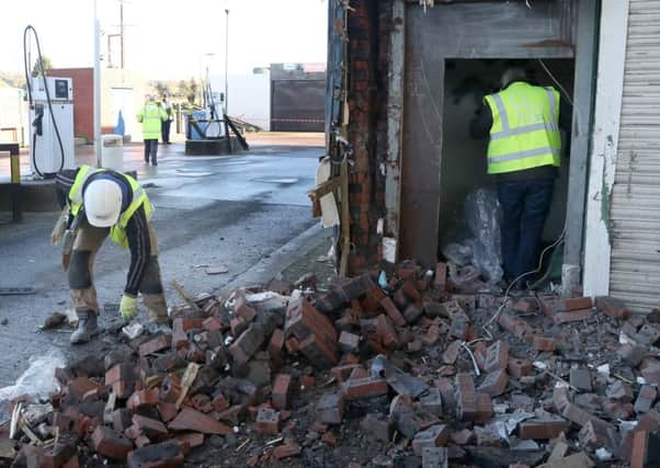 Workers pick through the rubble of the ATM removed from a Spar store on the Glenavy Road in Moira