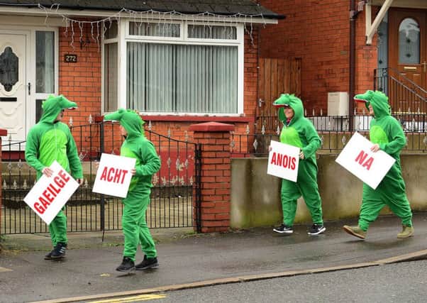 Sinn Fein members (whose sign reads 'Irish language act now' in Irish) pull a stunt at the offices of the DUP's Nelson McCausland on the Ballysillan Road in Belfast, Feburary 2017