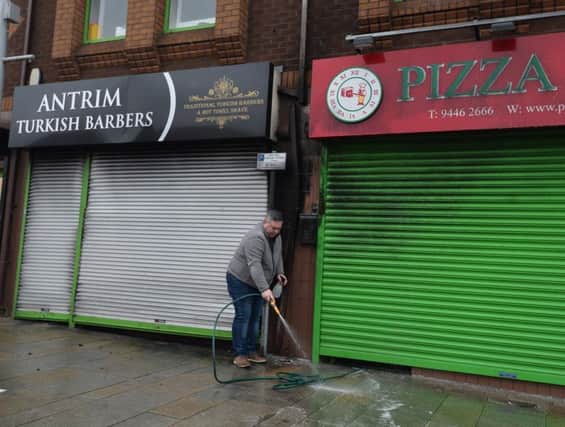 Owner of the Pizza shop Michael Johnson  cleans up after A fire at a Turkish barbers in Antrim is being investigated by police as suspected arson.   Photo Colm Lenaghan/Pacemaker Press