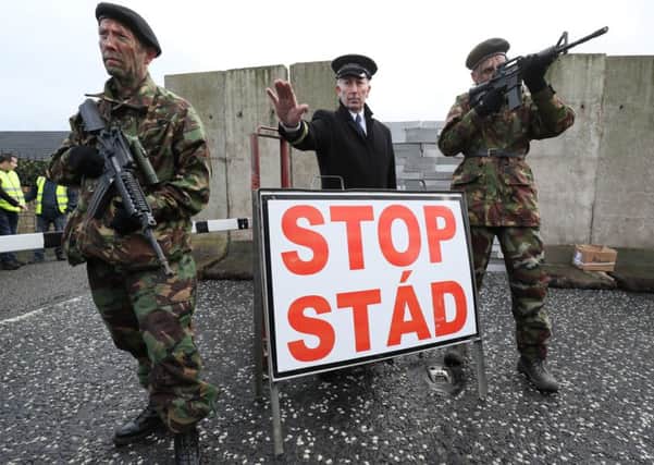 This mock checkpoint by actors is what most people assume a hard border entails - but Theresa May has signed up to a far more sweeping definition. Photo: Brian Lawless/PA Wire
