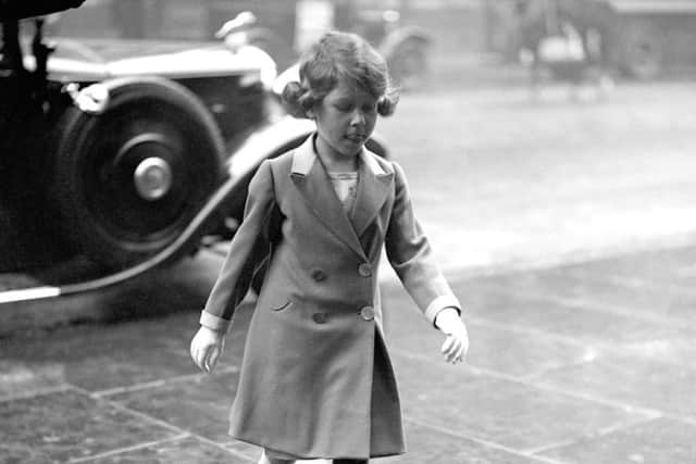 Princess Elizabeth walking bareheaded through the rain to visit the Royal Tournament at Olympia in London.