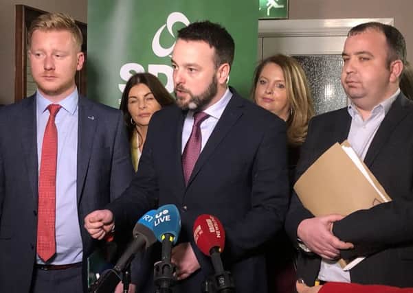 SDLP leader Colum Eastwood (centre) speaks to the media after his party voted to back a new partnership with Irelands main opposition party, Fianna Fail