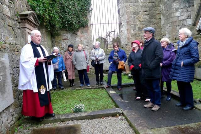 Canon Sims leads a commemoration at Henry Harrison's graveside in the Old Priory in Holywood