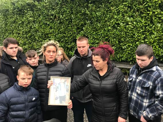 Ellie Ward (centre left), wife of Co Tyrone murder victim Pat Ward holding a photograph of her husband after watching the two people charged with his death appear at Dungannon Magistrates' Court on Wednesday